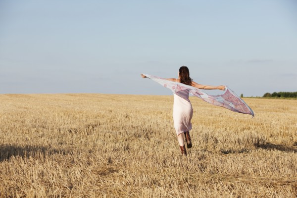 France, Picardie, Albert, Young woman running through stubble with shawl. 
Photo: Jan Scherders