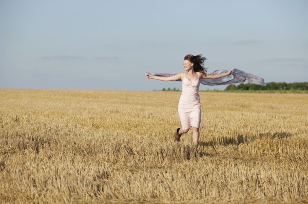 France, Picardie, Albert, Young woman running through stubble with shawl. 
Photo: Jan Scherders