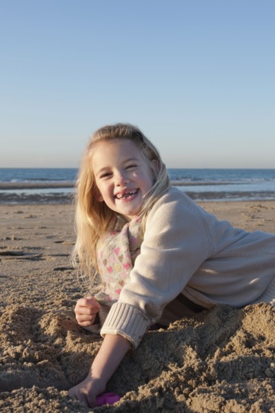 Netherlands, Zeeland, Haamstede, Girl digging sand on beach. 
Photo: Jan Scherders