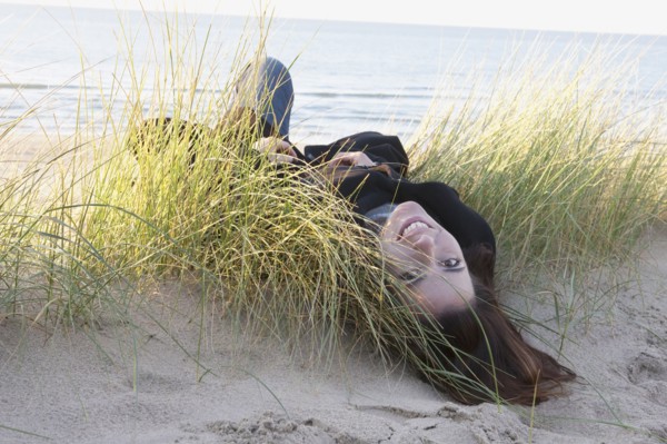 Netherlands, Zeeland, Haamstede, Woman lying on sand dune. 
Photo : Jan Scherders