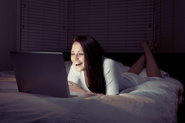 Woman using laptop in bed. 
Photo: King Lawrence