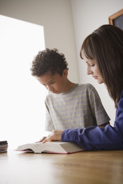 Schoolboy reading with teacher in classroom. 
Photo : Rob Lewine