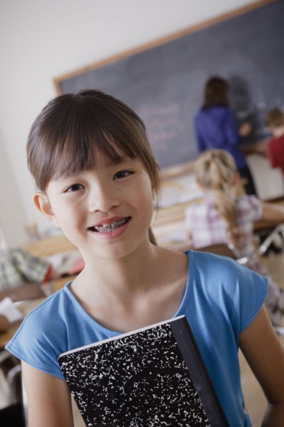 Portrait of schoolgirl holding notebook. 
Photo : Rob Lewine