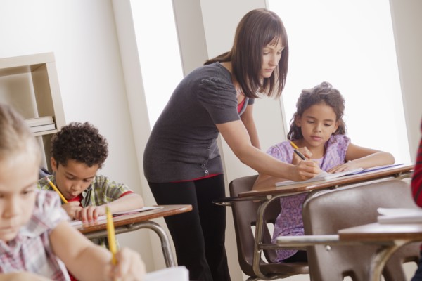 Teacher helping schoolchildren (6-7,8-9). 
Photo: Rob Lewine