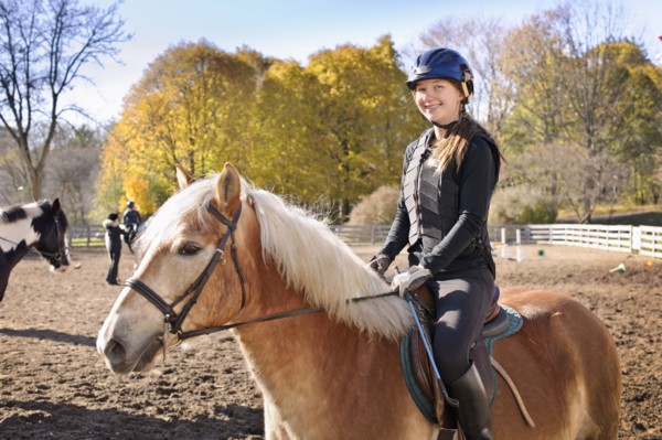 Canada, Ontario, Toronto, Portrait of teenage girl (16-17) riding on horse. 
Photo : Elena