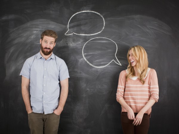 Young couple with speech bubble on blackboard, studio shot. 
Photo: Jessica Peterson