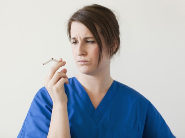 Young woman examining broke cigarette. 
Photo : Jessica Peterson