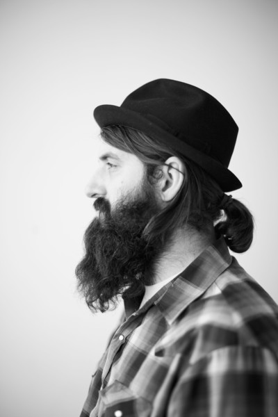 Profile of male character wearing long beard, hat and lumberjack shirt. 
Photo : Jessica Peterson