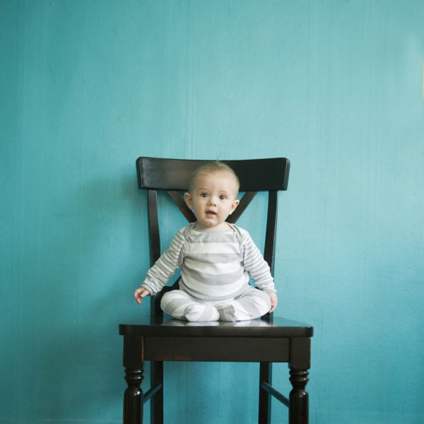 Toddler boy (2-3) sitting on tall chair on blue background. 
Photo : Jessica Peterson