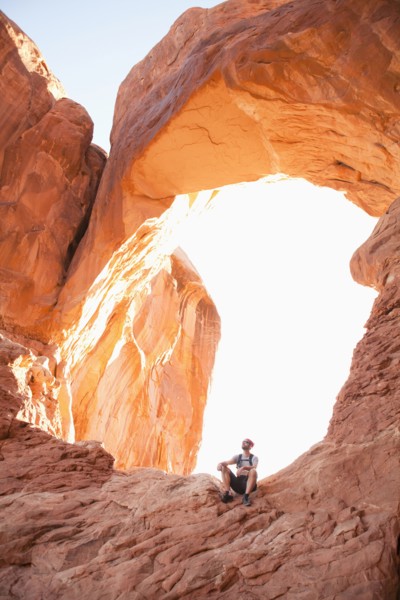 USA, Utah, Moab, Mid adult man posing in front of natural arches. 
Photo: Jessica Peterson
