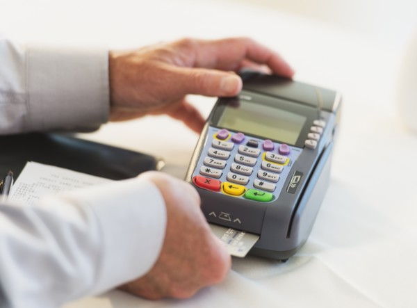 Man inserting credit card in credit card machine.