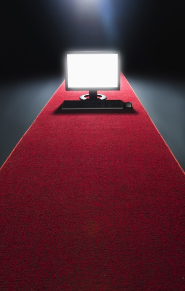Studio shot of glowing computer on red carpet.