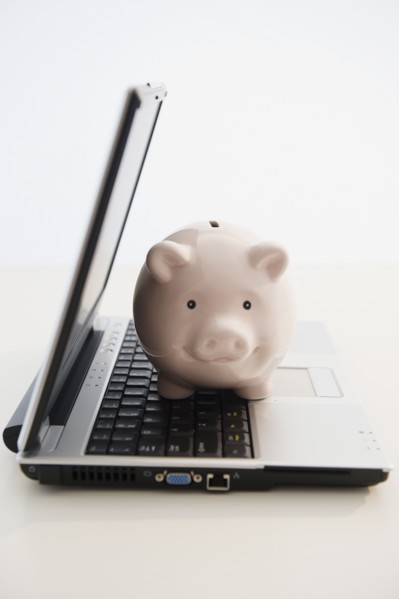 Piggybank sitting in open laptop. Photo : Jamie Grill