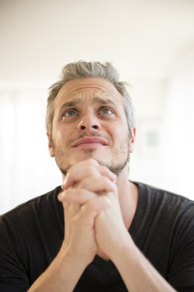 Mid adult man in praying gesture. Photo: Jamie Grill