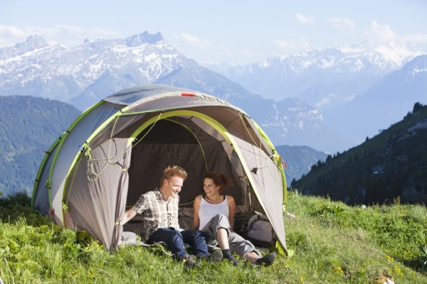 Switzerland, Leysin, Hikers resting in tent pitched on meadow. Photo: Mike Kemp