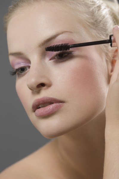 Beauty portrait of woman using mascara. Photo : Jan Scherders