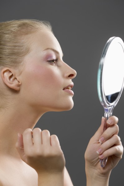 Beauty portrait of woman looking in mirror. Photo : Jan Scherders