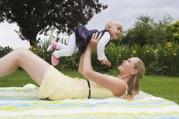 Young mother playing with daughter outdoor. Photo: Mark de Leeuw