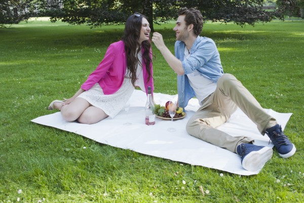 Couple having picnic in park. Photo : Mark de Leeuw