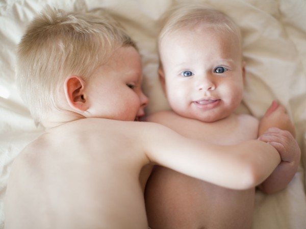 Portrait of boy (2-3) with baby sister (6-11 months). Photo : Jessica Peterson