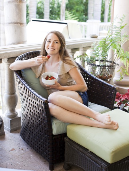 Portrait of young woman having strawberry. Photo : Jessica Peterson