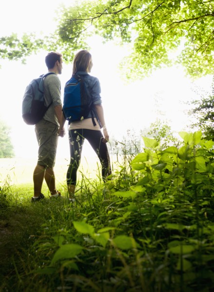 Couple hiking in forest. Photo: Tetra Images