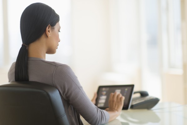Businesswoman using digital tablet in office.