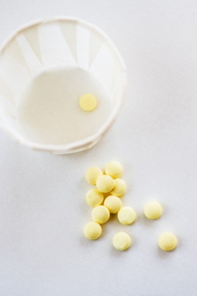 Yellow pills with cup, studio shot.