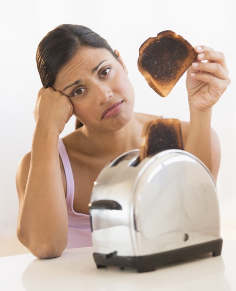 Studio shot of woman holding burnt toast.