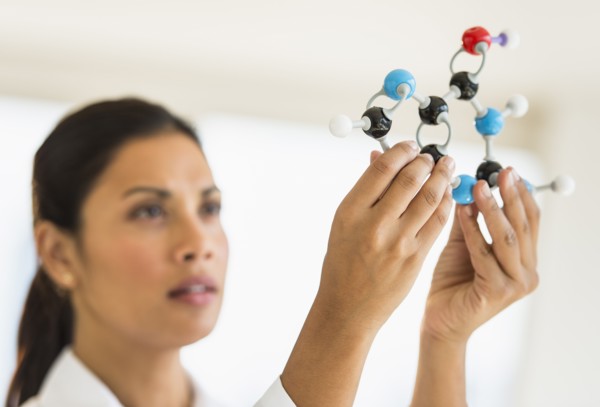 Female scientist holding molecule model.