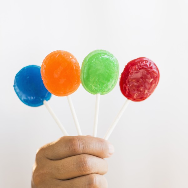 Hand holding colorful lollypops.