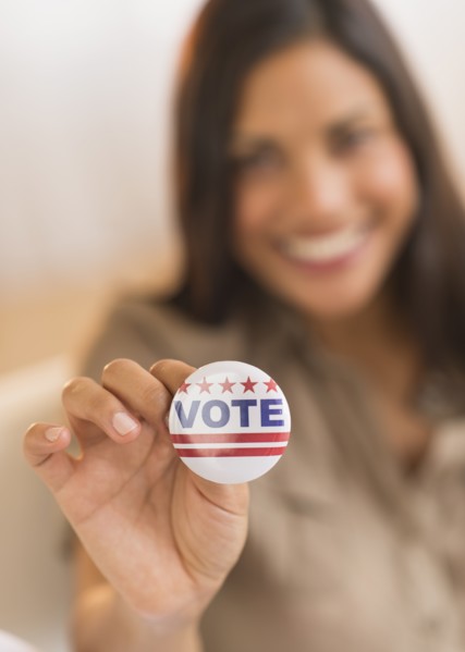 Woman holding vote button.