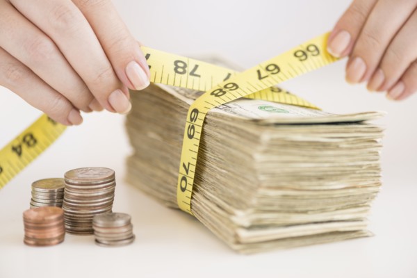 Woman measuring bunch of banknotes.