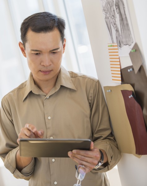Mid adult fashion designer using digital tablet. Photo : Daniel Grill