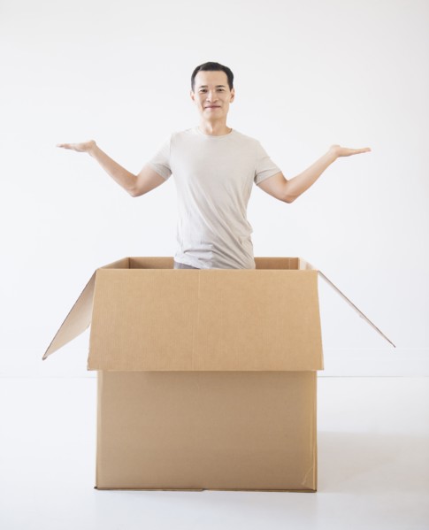 Man popping out from cardboard box. Photo : Daniel Grill