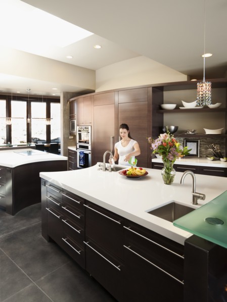 Young woman bustling around in modern domestic kitchen.