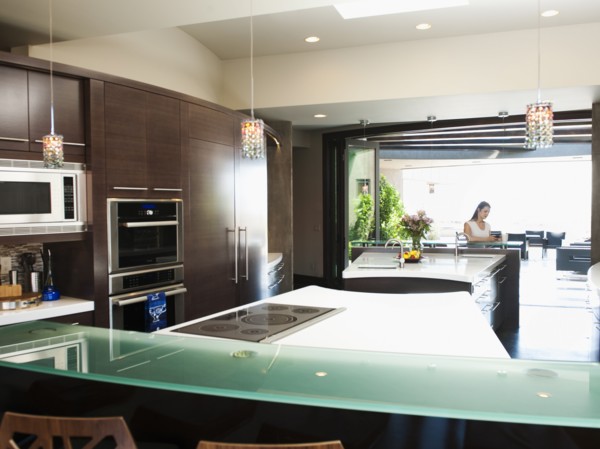 Young woman bustling around in modern domestic kitchen. Photo: Erik Isakson