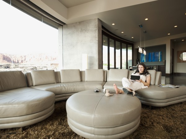 Young attractive woman using digital tablet while sitting in her living room. Photo: Erik Isakson