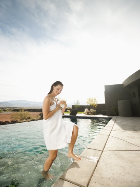 Young attractive woman emerging from swimming pool.