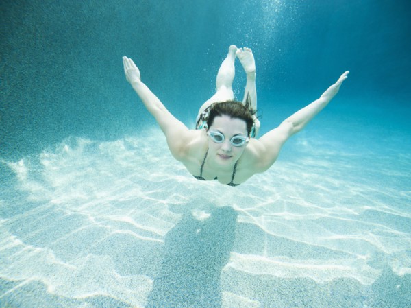 Young attractive woman diving in swimming pool.