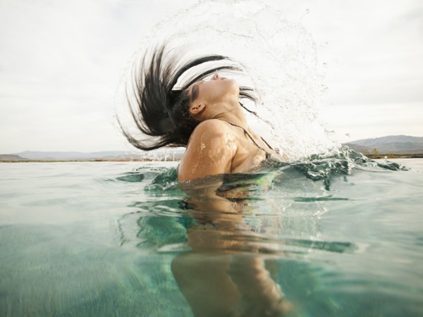 Attractive young woman emerging from swimming pool.