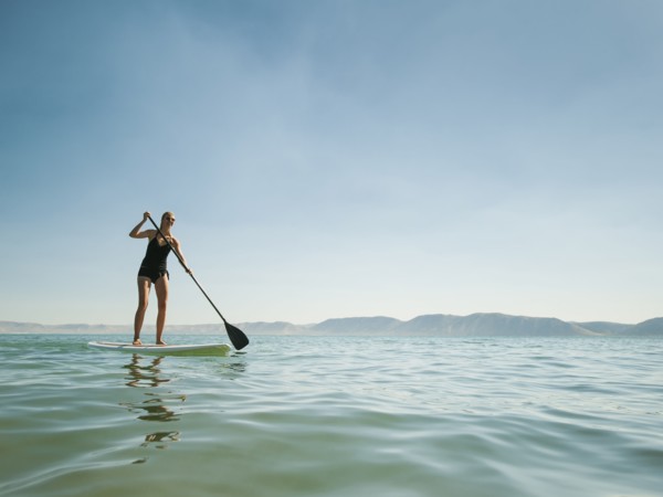 Young woman standing on paddleboard.