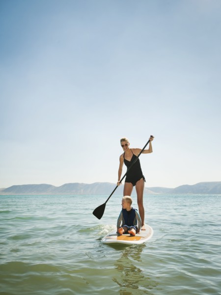 Young woman with daughter (4-5) on paddleboard.