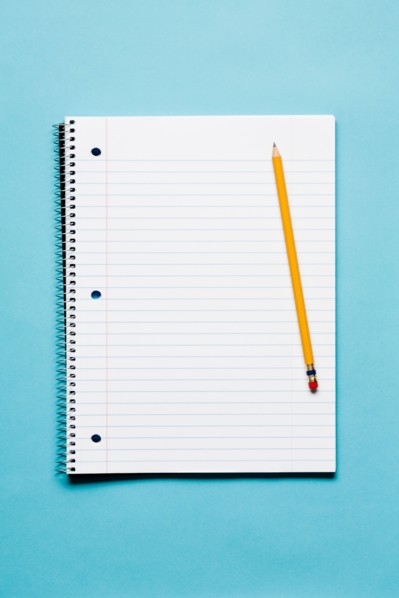 Single yellow sharpened pencil with blank spiral notebook on blue background. Photo: Kristin Duvall
