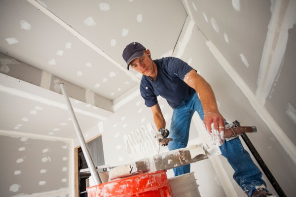 Drywall worker adding drywall mud to his banjo. Photo: Mike Kemp