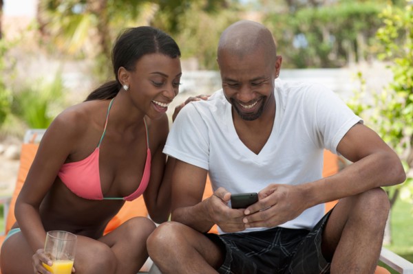 African American couple socializing around pool. Photo : Dan Bannister