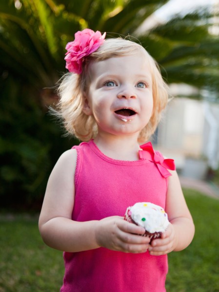 Girl holding cupcake. Photo : Jessica Peterson