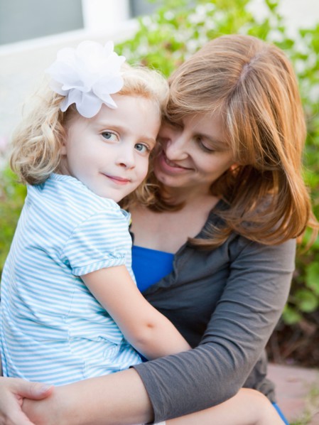 Portrait of mother and her daughter sitting on her lap. Photo : Jessica Peterson