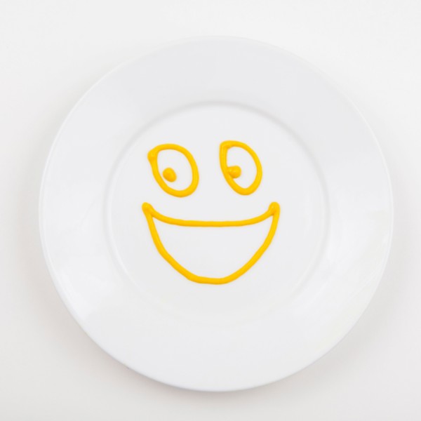 Plate with smiley face made of mustard. Photo : Jessica Peterson