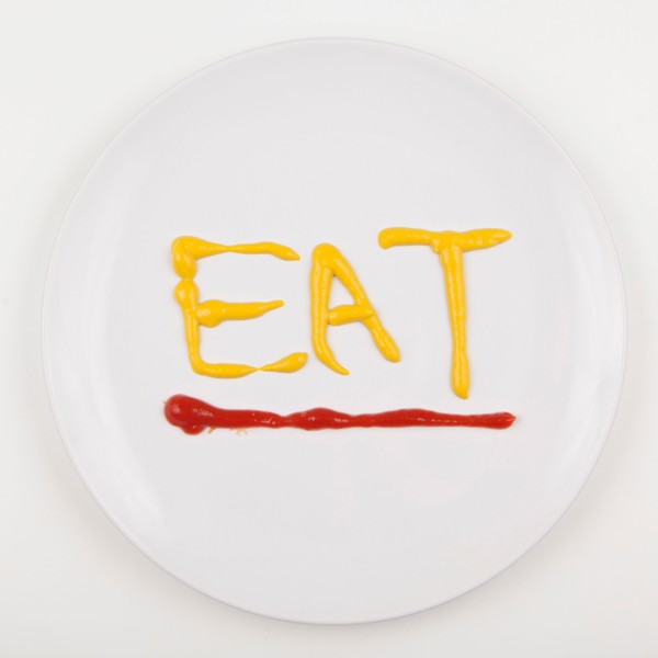 Word EAT written with mustard and ketchup. Photo : Jessica Peterson